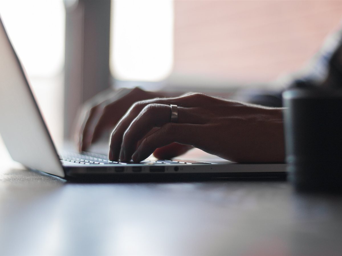 Hands typing on a laptop keyboard